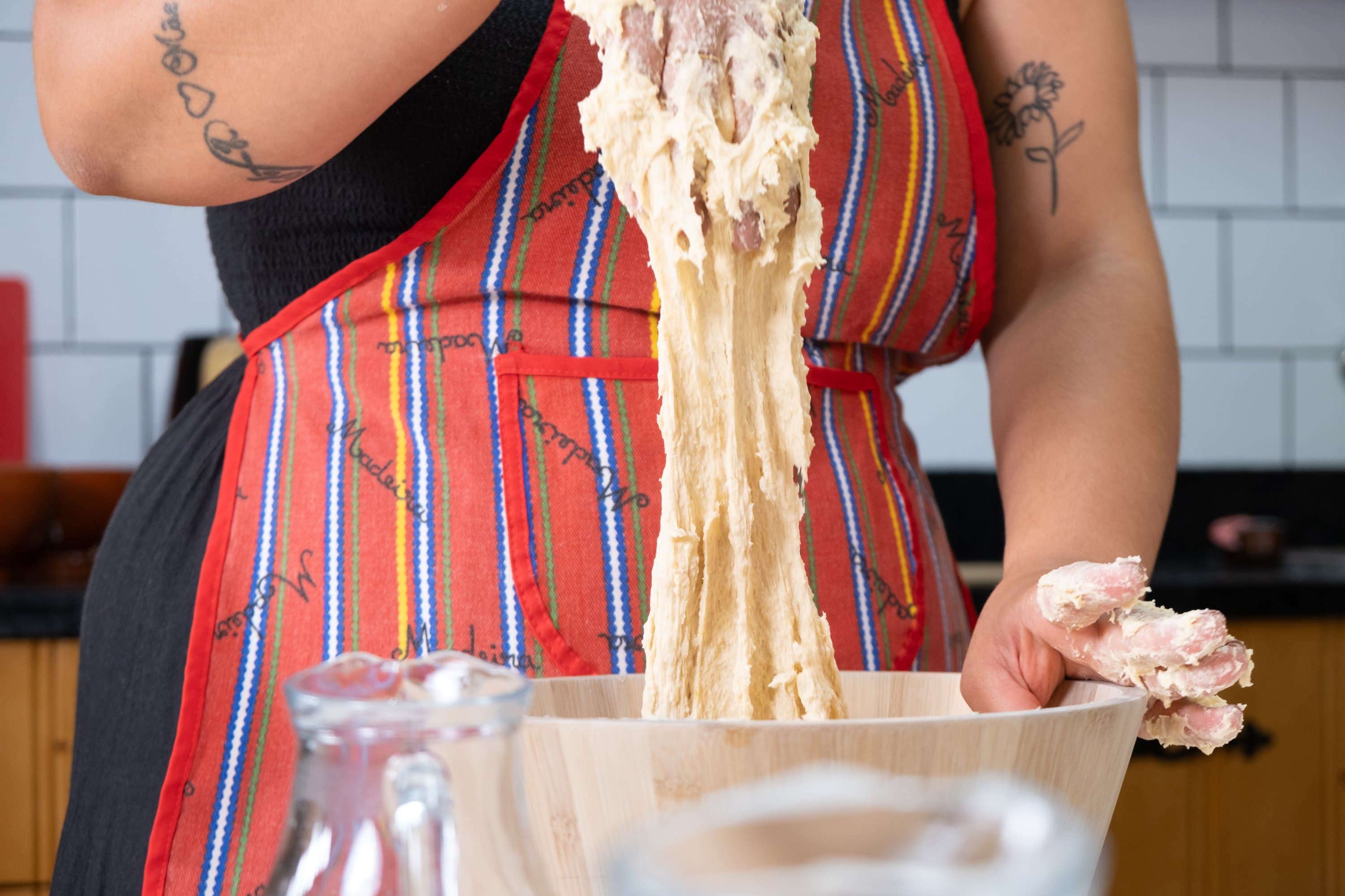 Hands working Bolo do Caco dough during the workshop.